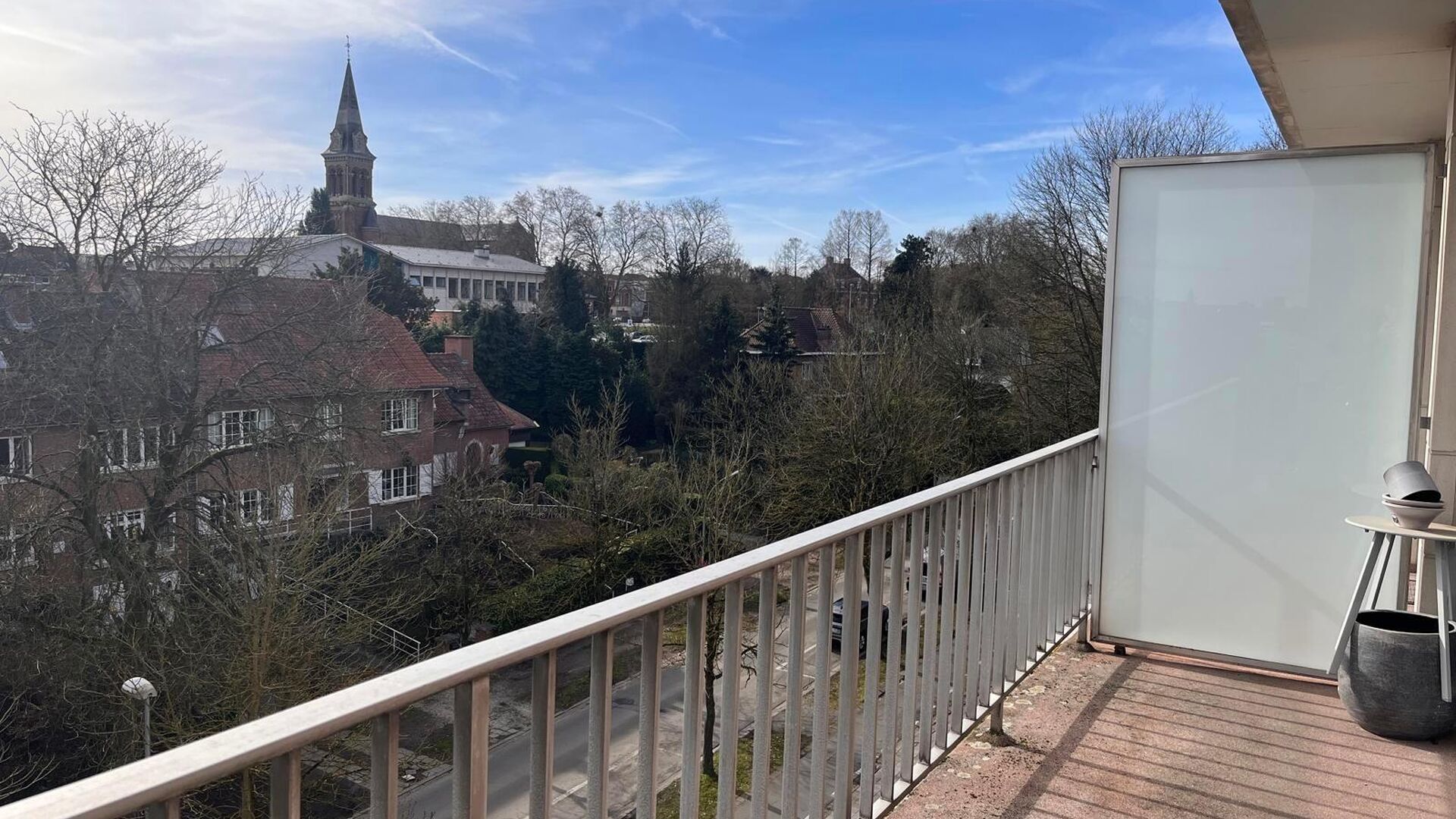 Residentie Woodside is gelegen op de Kardinaal Mercierlaan, volledig omgeven door groen.  Het appartement is gelegen op de vierde verdieping en omvat ruime inkomhal met ingebouwde vestiaire,  volledig geïnstalleerde keuken (vaatwas, frigo met diepvries, 