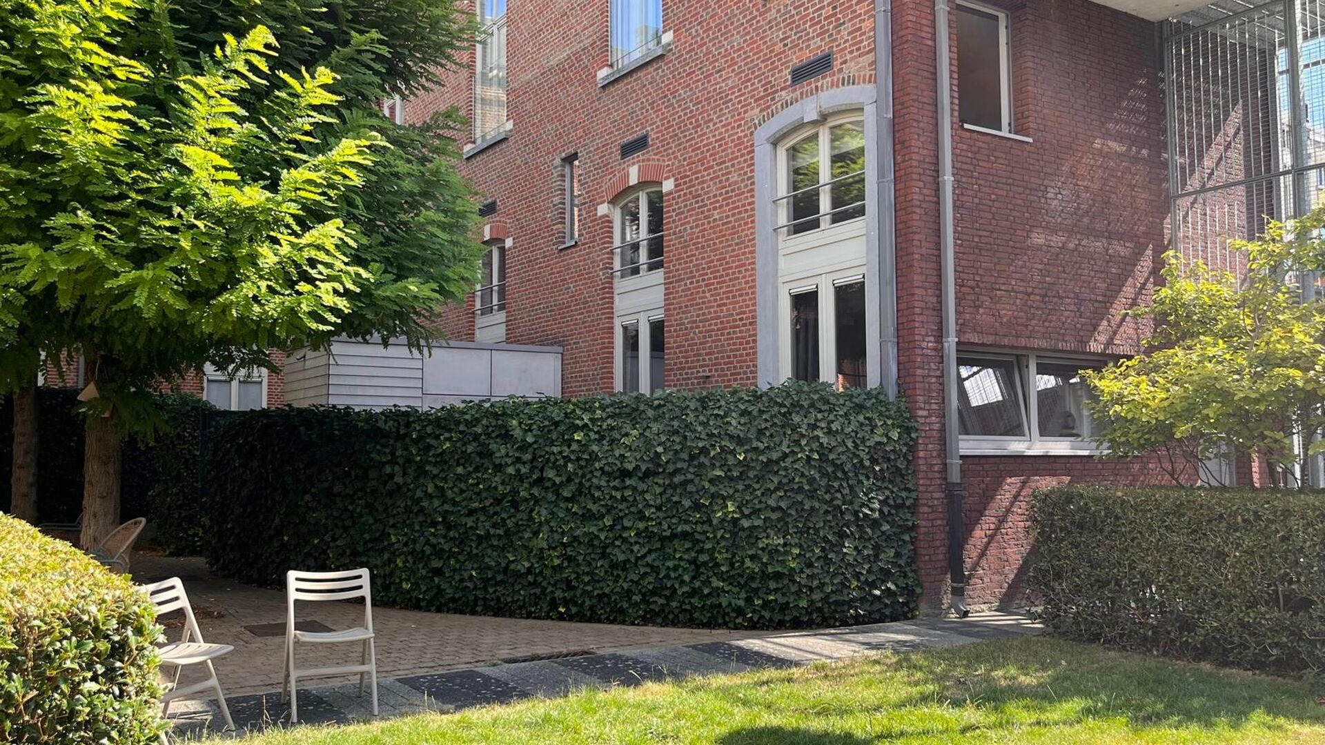 Dit knap duplex-appartement, gelegen in de voormalige rijkswachtkazerne, geeft uit op de groene binnenkoer en heeft hier eveneens zijn privatieve ingang en terras van +- 25 m² met aparte berging. Het appartement is volledig gemeubeld en heeft volgende in