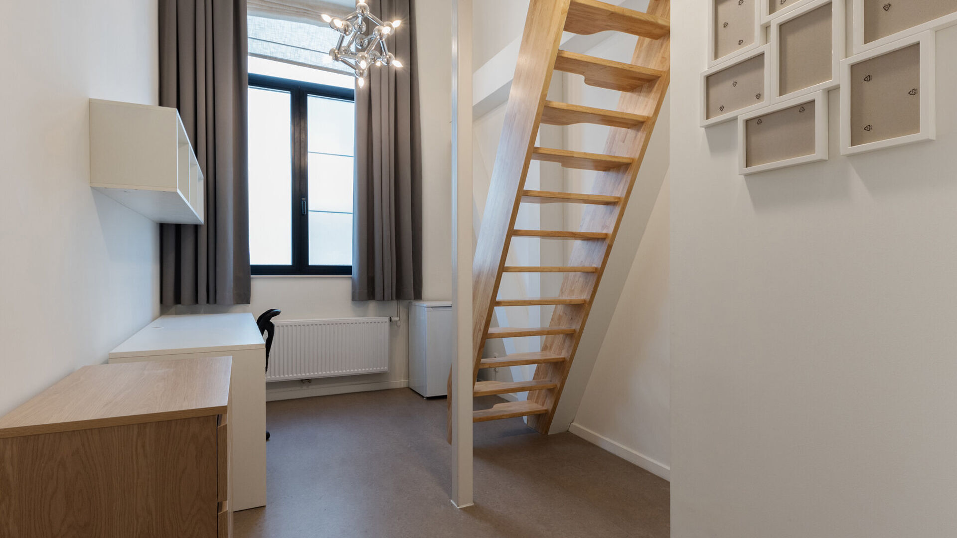 New student room in a triplex layout within the prestigious Campus Vital project. This student room is located on the first floor. The sleeping area is arranged as a duplex, while the bathroom is situated on the lower level. The room is furnished with a b