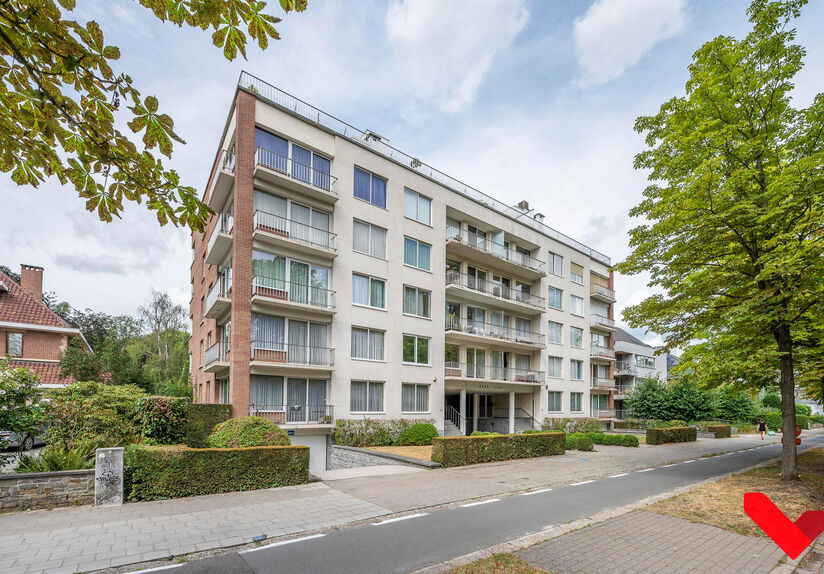 Residentie Woodside is gelegen op de Kardinaal Mercierlaan, volledig omgeven door groen. Het appartement is gelegen op de vierde verdieping en omvat ruime inkomhal met ingebouwde vestiaire, volledig geïnstalleerde keuken (vaatwas, frigo met diepvries,