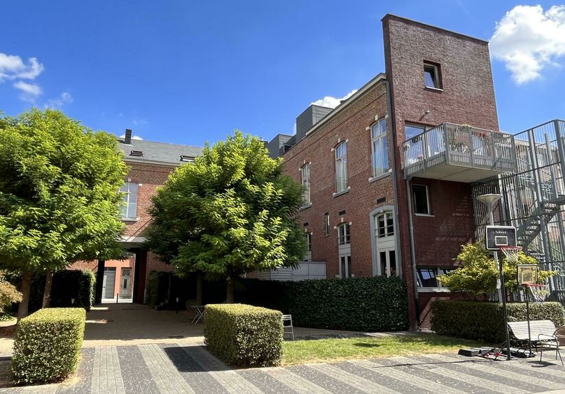 This handsome duplex apartment, located in the former gendarmerie barracks, overlooks the green courtyard and has its private entrance and terrace of +- 25 m² with separate storage room. The apartment is fully furnished and has the following layout: entr